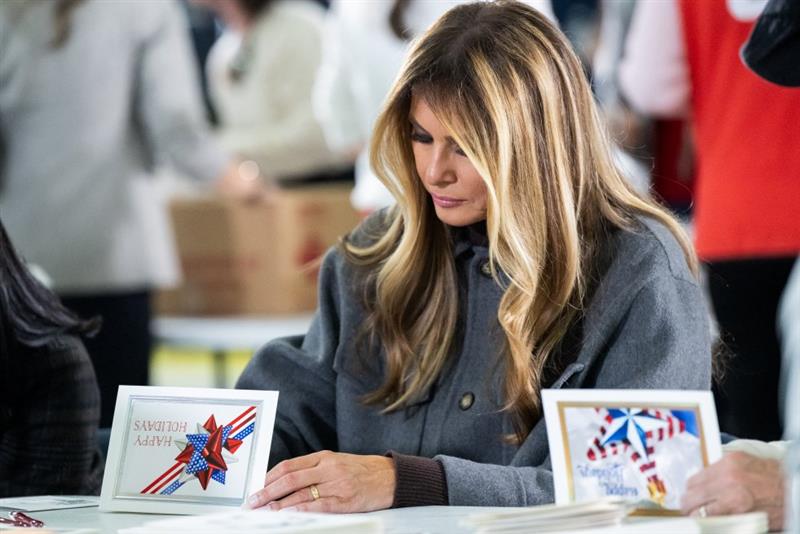 The First Lady signs a patriotic holiday card during a Red Cross holiday care-package event for service members.